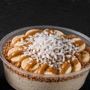 Coco Power super bowl: coconut base topped with banana slices, peanut butter drizzle and shredded coconut